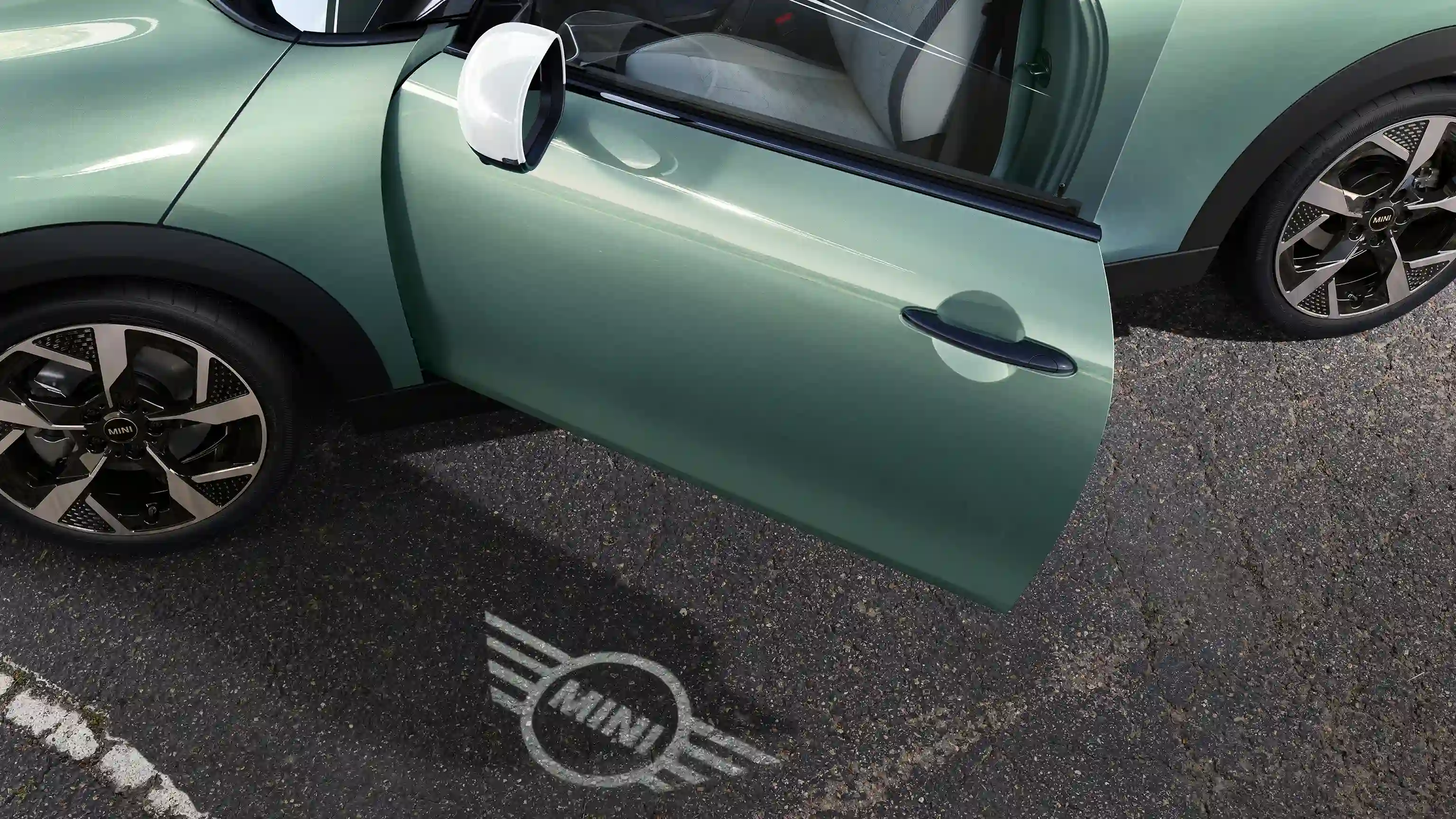 MINI Cooper kívülről, nyitott ajtóval és MINI logós üdvözlőfénnyel a földön 