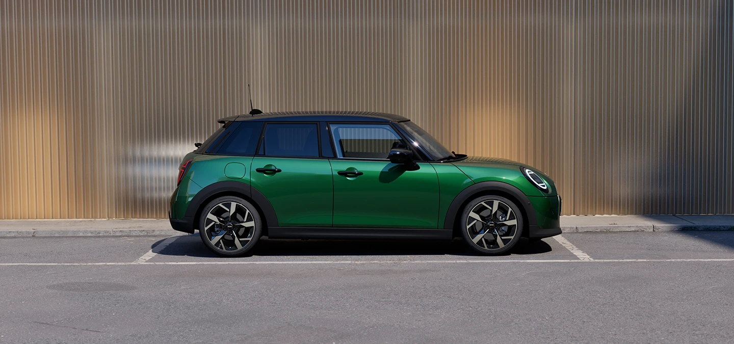Az 5 ajtós MINI Cooper oldalnézetből, British Racing Green színben, fekete tetővel.