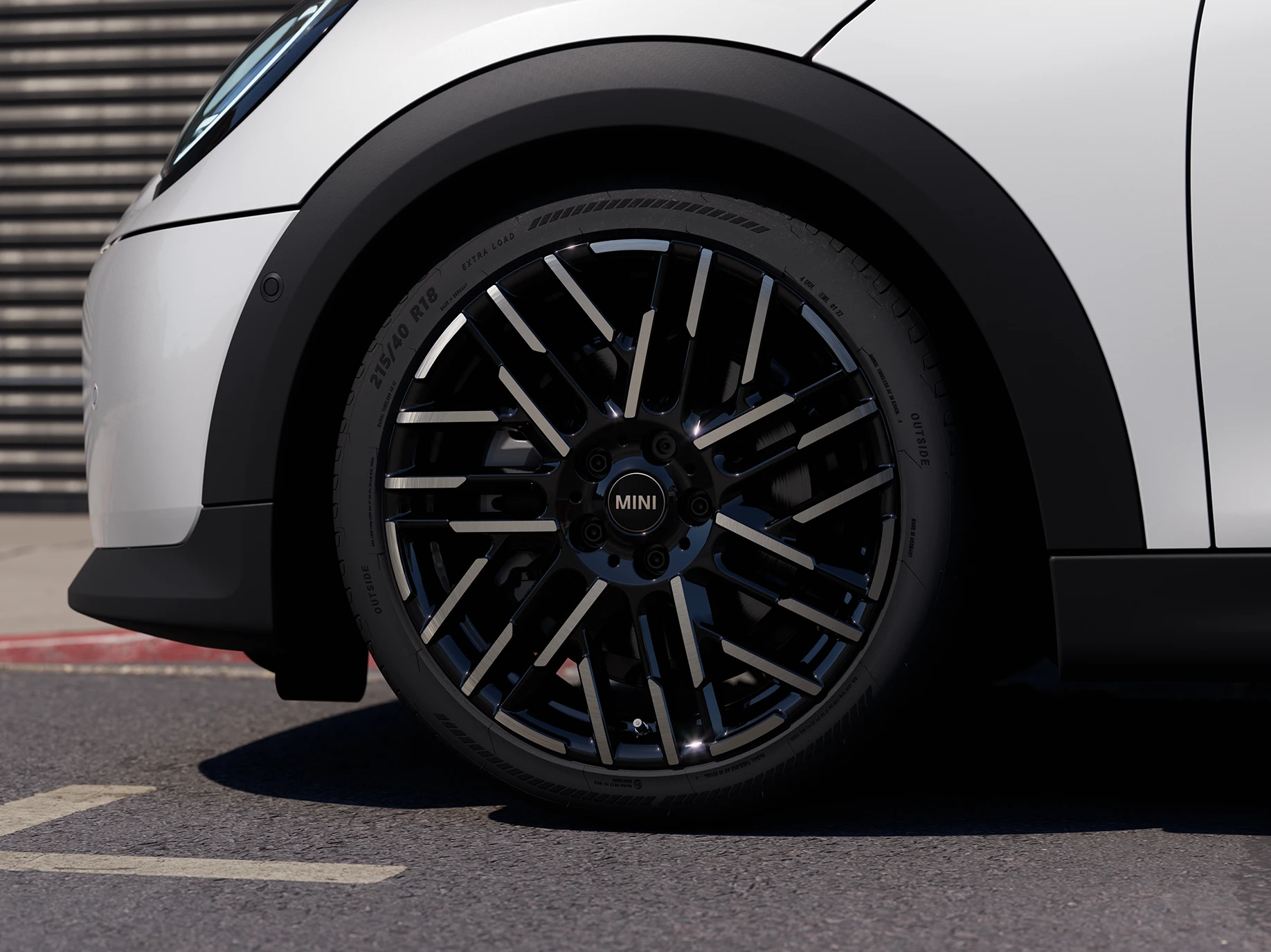 Az 5 ajtós MINI Cooper közeli képe, Nanuq White színben, Night Flash Spoke kétszínű keréktárcsákkal.