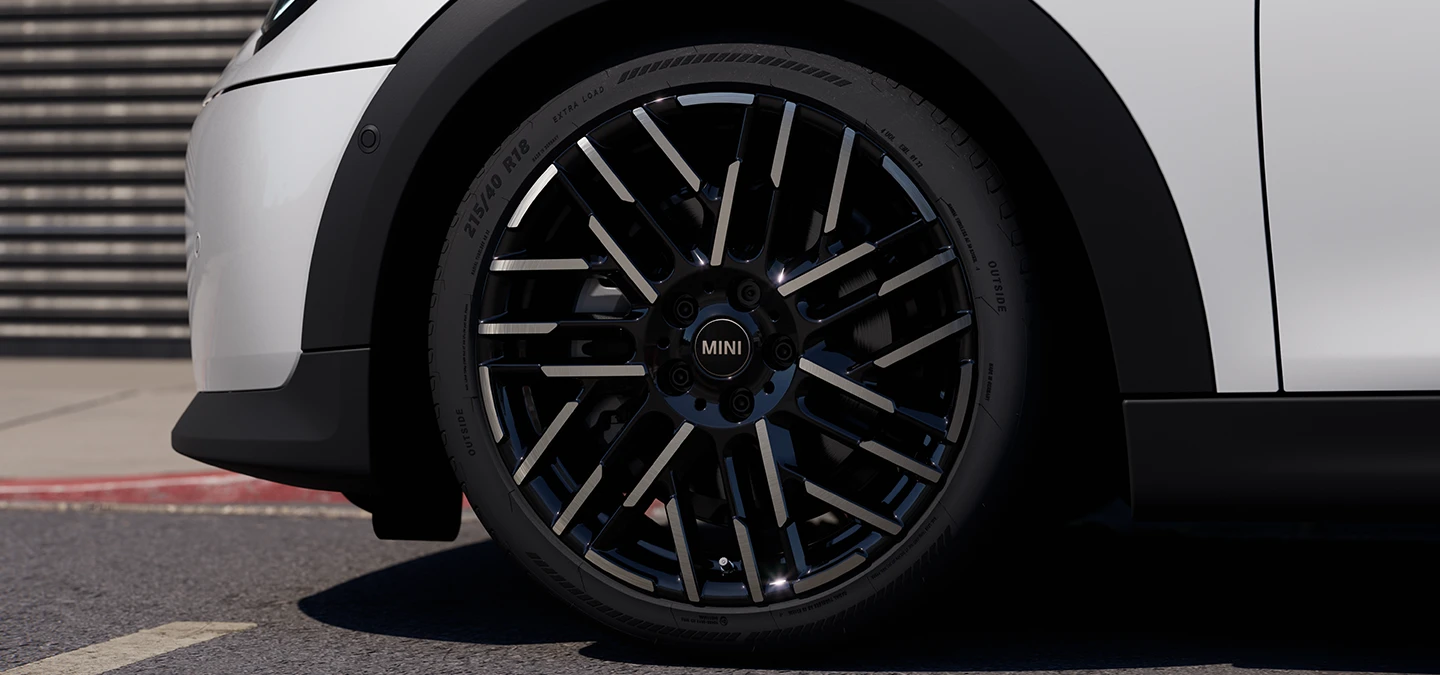 Az 5 ajtós MINI Cooper közeli képe, Nanuq White színben, Night Flash Spoke kétszínű keréktárcsákkal.