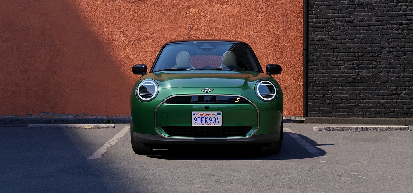 Egy tisztán elektromos MINI Cooper elülnézete, British Racing Green színben, fekete tetővel.