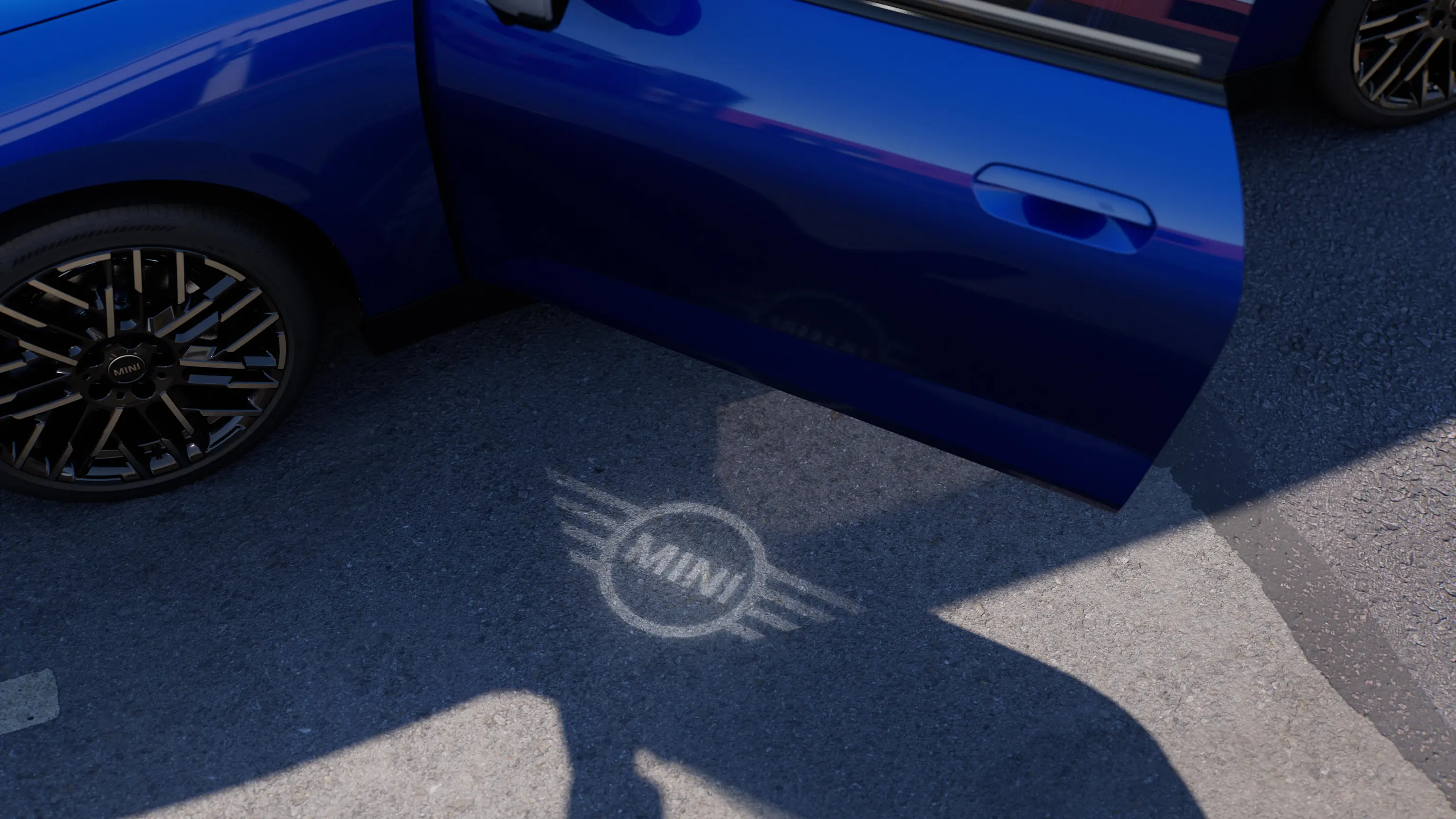 Egy tisztán elektromos MINI Cooper külseje nyitott ajtóval, és a talajra vetített üdvözlő MINI logóval