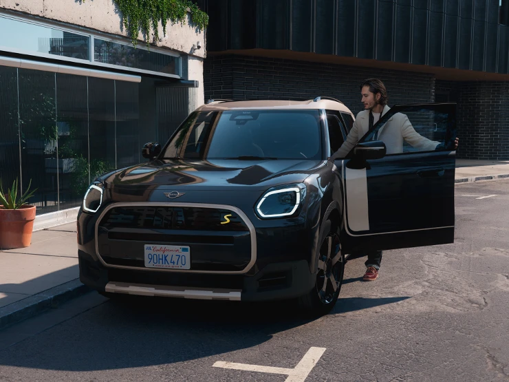 A tisztán elektromos MINI Countryman elölnézete, Midnight Black színben, Vibrant Silver színű tetővel.