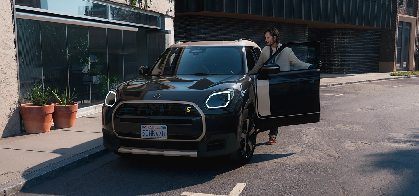 A tisztán elektromos MINI Countryman elölnézete, Midnight Black színben, Vibrant Silver színű tetővel.