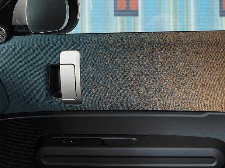 A tisztán elektromos MINI Countryman belső dizájnja közelről, az ajtóra és a műszerfalra összpontosítva.