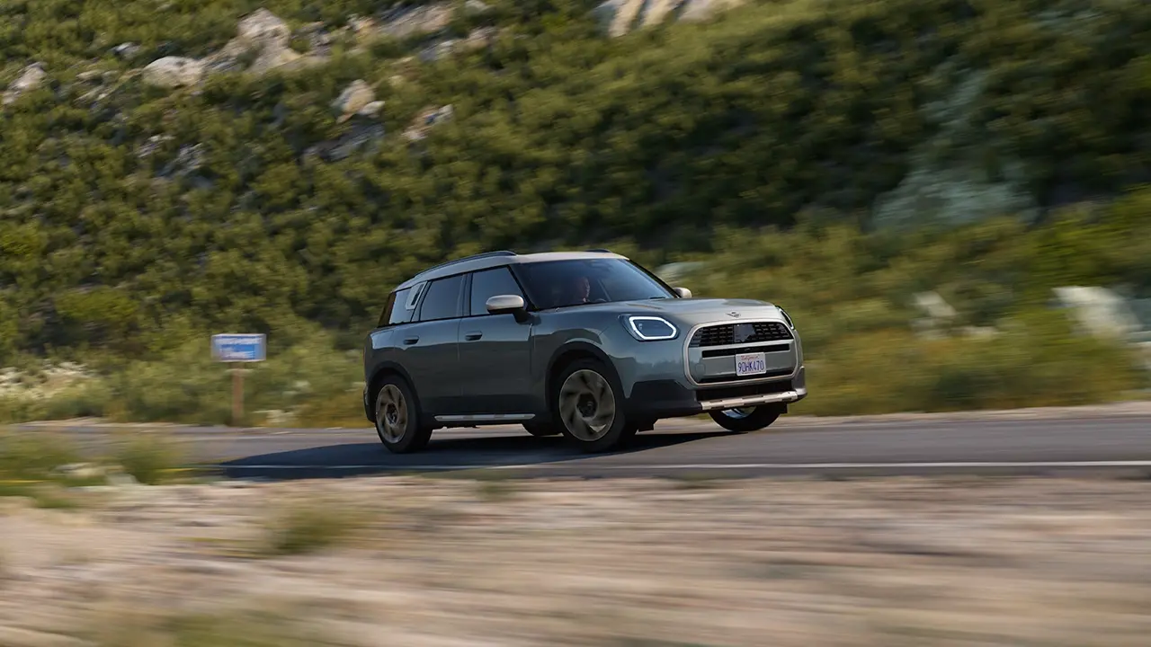 A terepen vezetett, Smokey Green fényezésű MINI Countryman képe (Favoured Style kivitel)