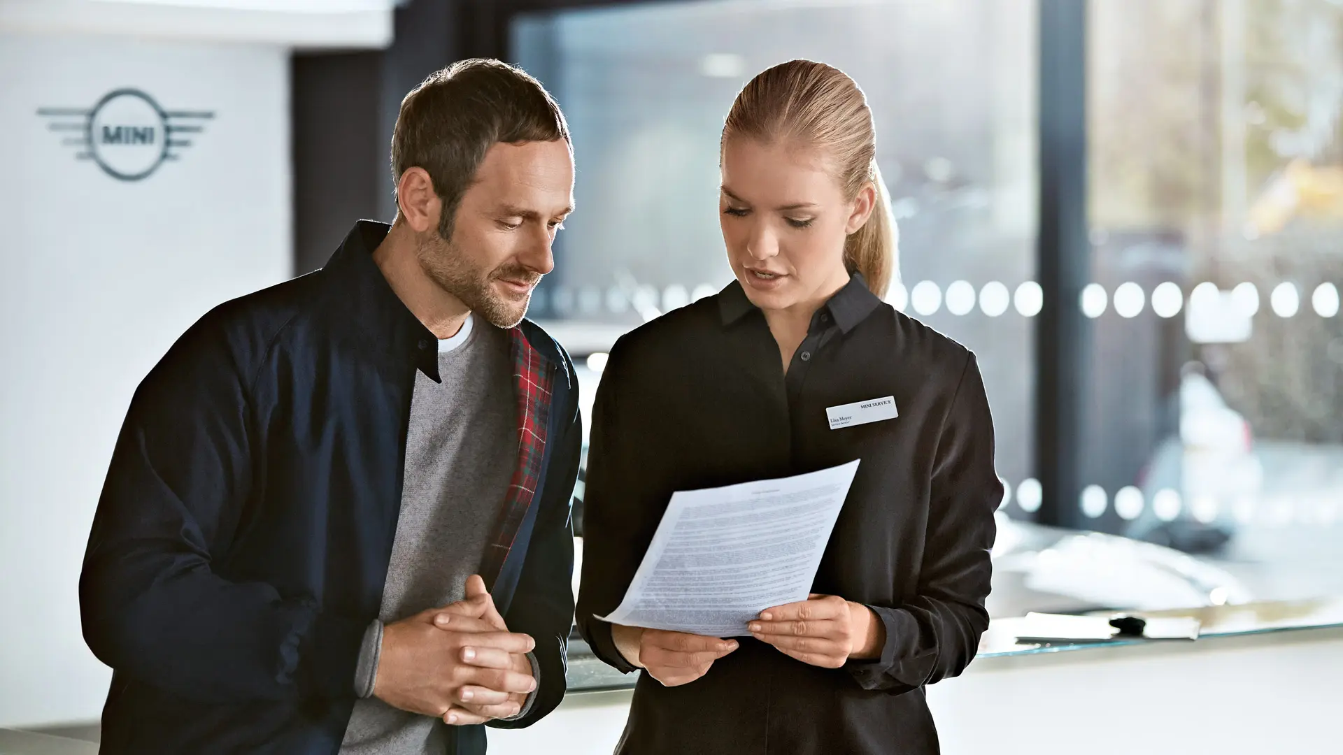 A MINI szerviztanácsadó tanácsot ad az ügyfélnek a szervizcsomagokkal kapcsolatban a MINI márkakereskedésben.