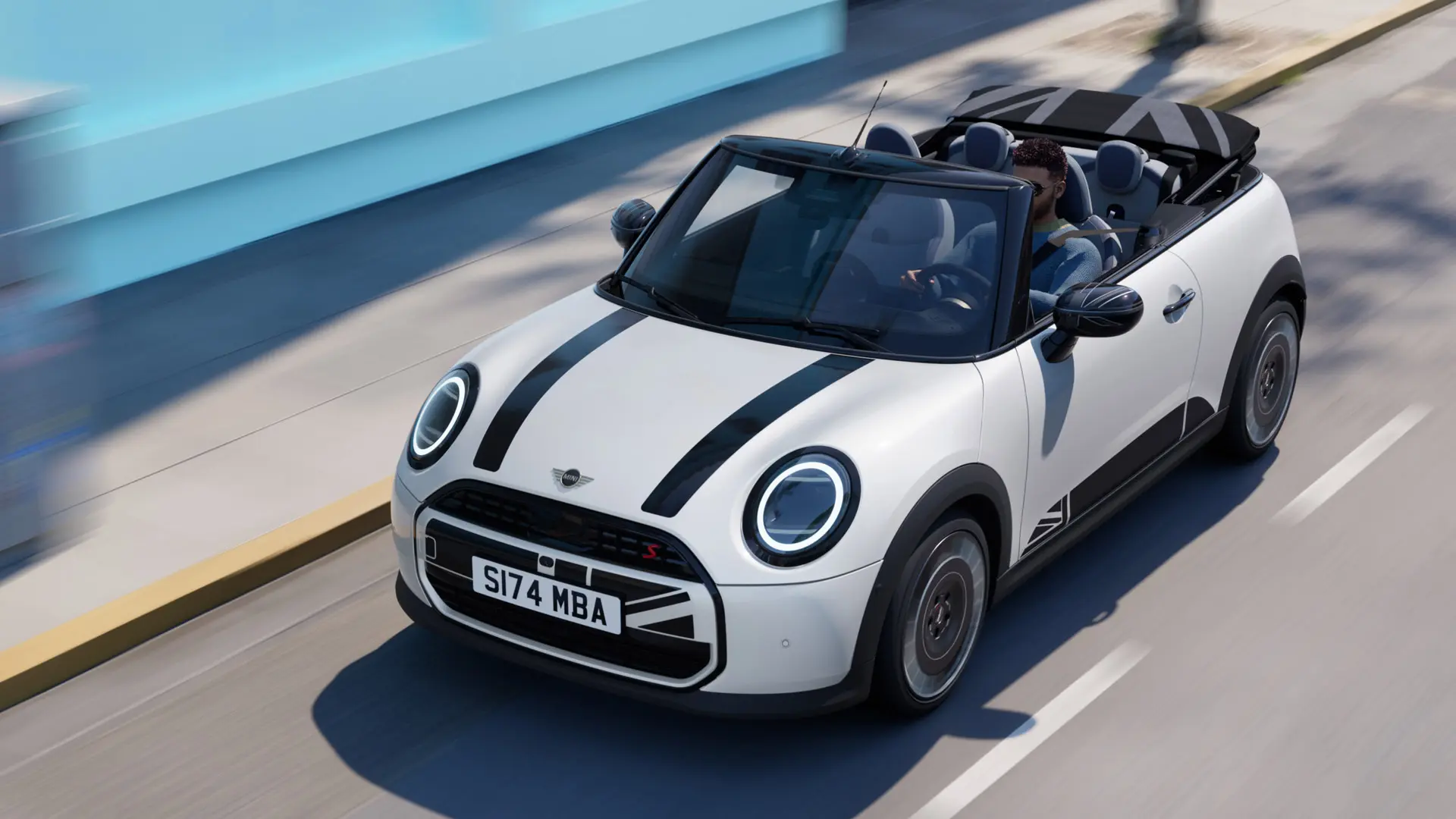 A MINI Cabrio felvétele Nanuq fehér színben, fekete MINI Heritage motorháztető matricáival. 