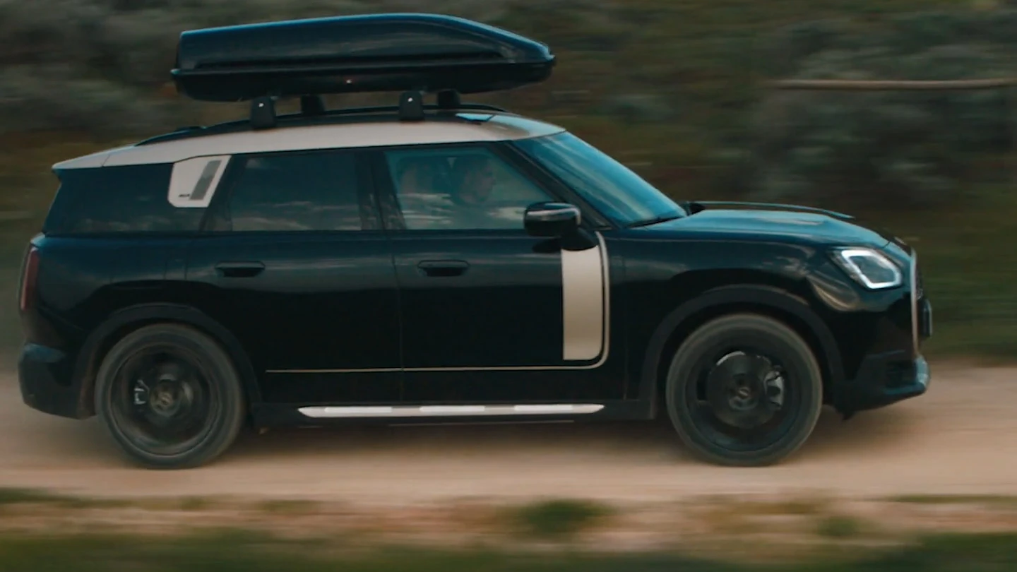 Midnight Black metál fényezésű MINI Countryman, fekete színű, 19" John Cooper Works Runway Spoke keréktárcsákkal terepen halad. 