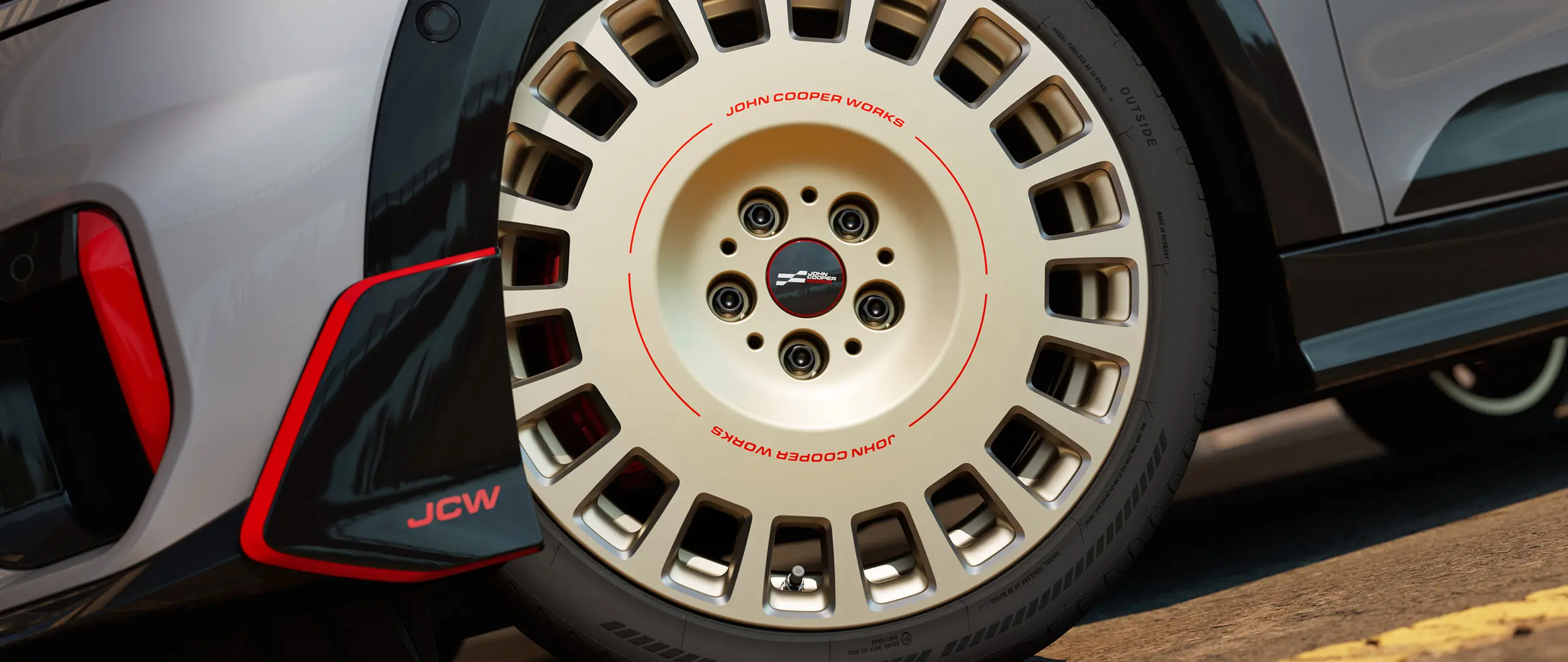 Közelkép a Vibrant Silver kétszínű, gyémántcsiszolással és első szárnytoldattal rendelkező 18" JCW Rallye Spoke 964 kerékről.