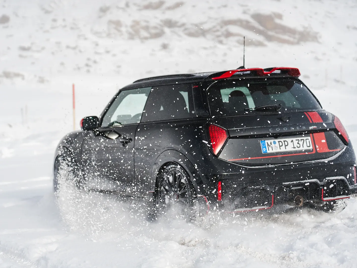 Egy hóban haladó MINI Cooper JCW hátulról.