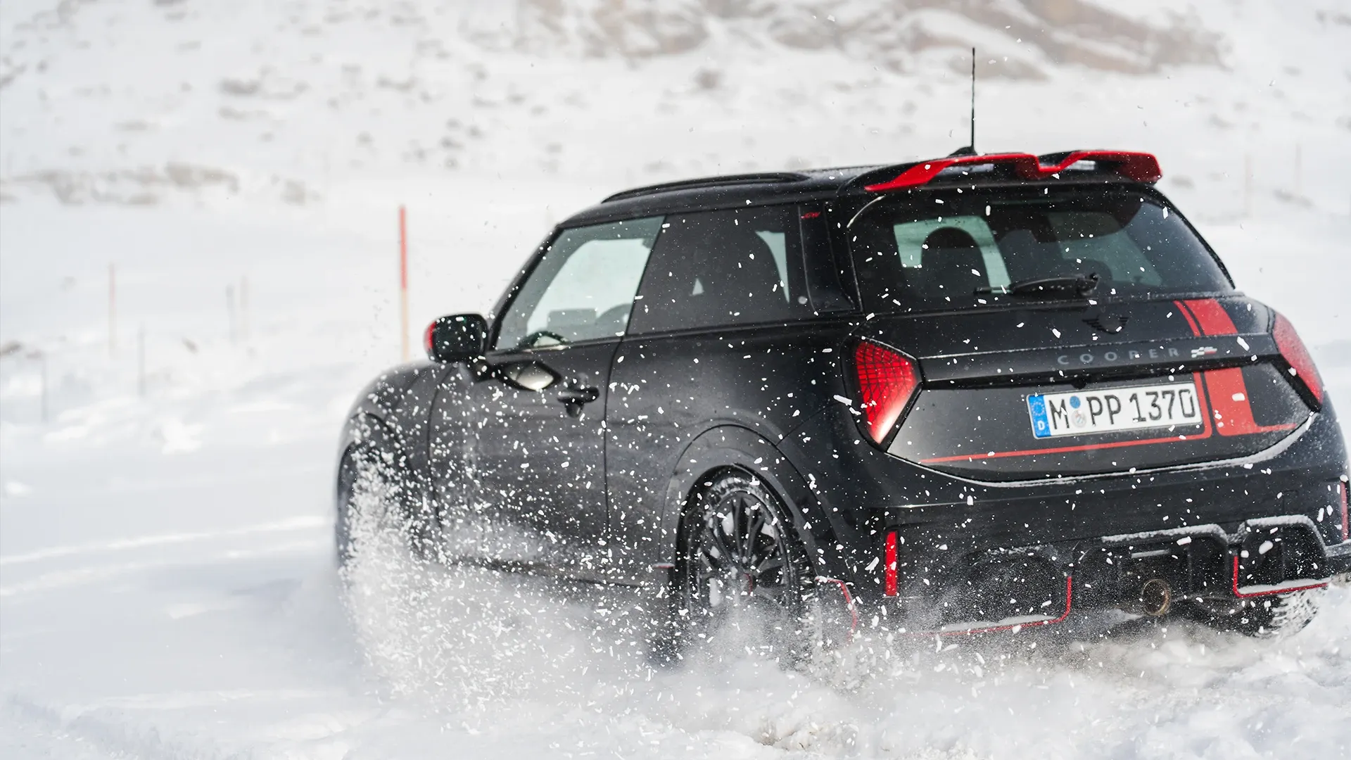 Egy hóban haladó MINI Cooper JCW hátulról.