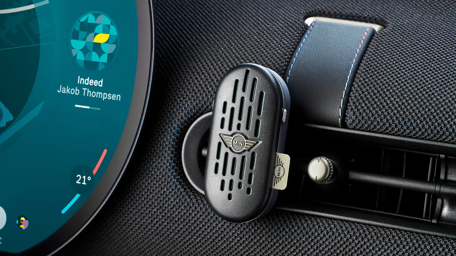 Egy MINI Aceman belső tere a kör alakú, érintőfunkciós OLED infotainment-kijelzővel és a műszerfalra erősített MINI Natural Air légfrissítővel.