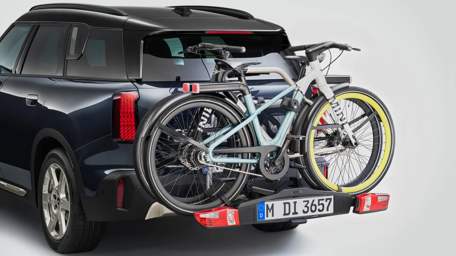 Egy fekete, hátsó kerékpártartóval – amelyen két mountain bike van – felszerelt MINI Countryman hátulnézetből.