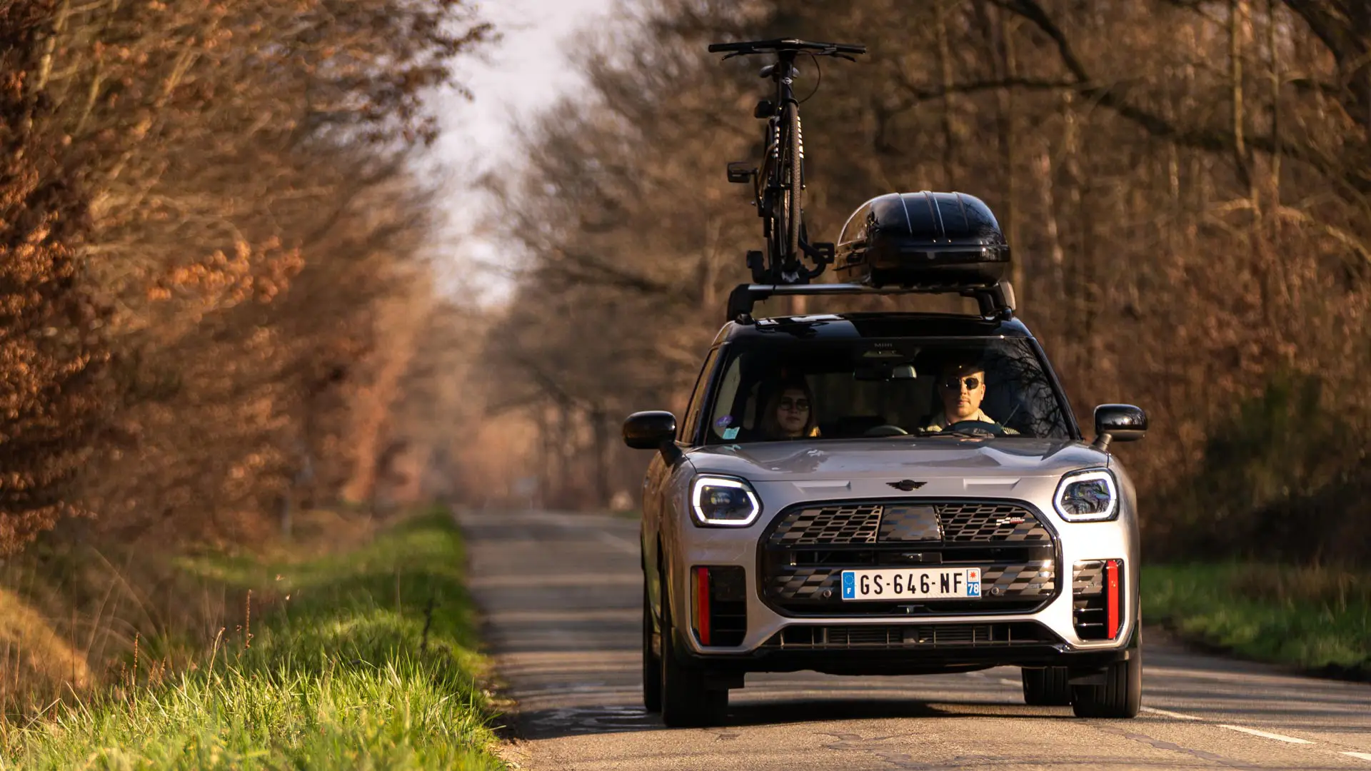 MINI Countryman tetőboxszal az úton.
