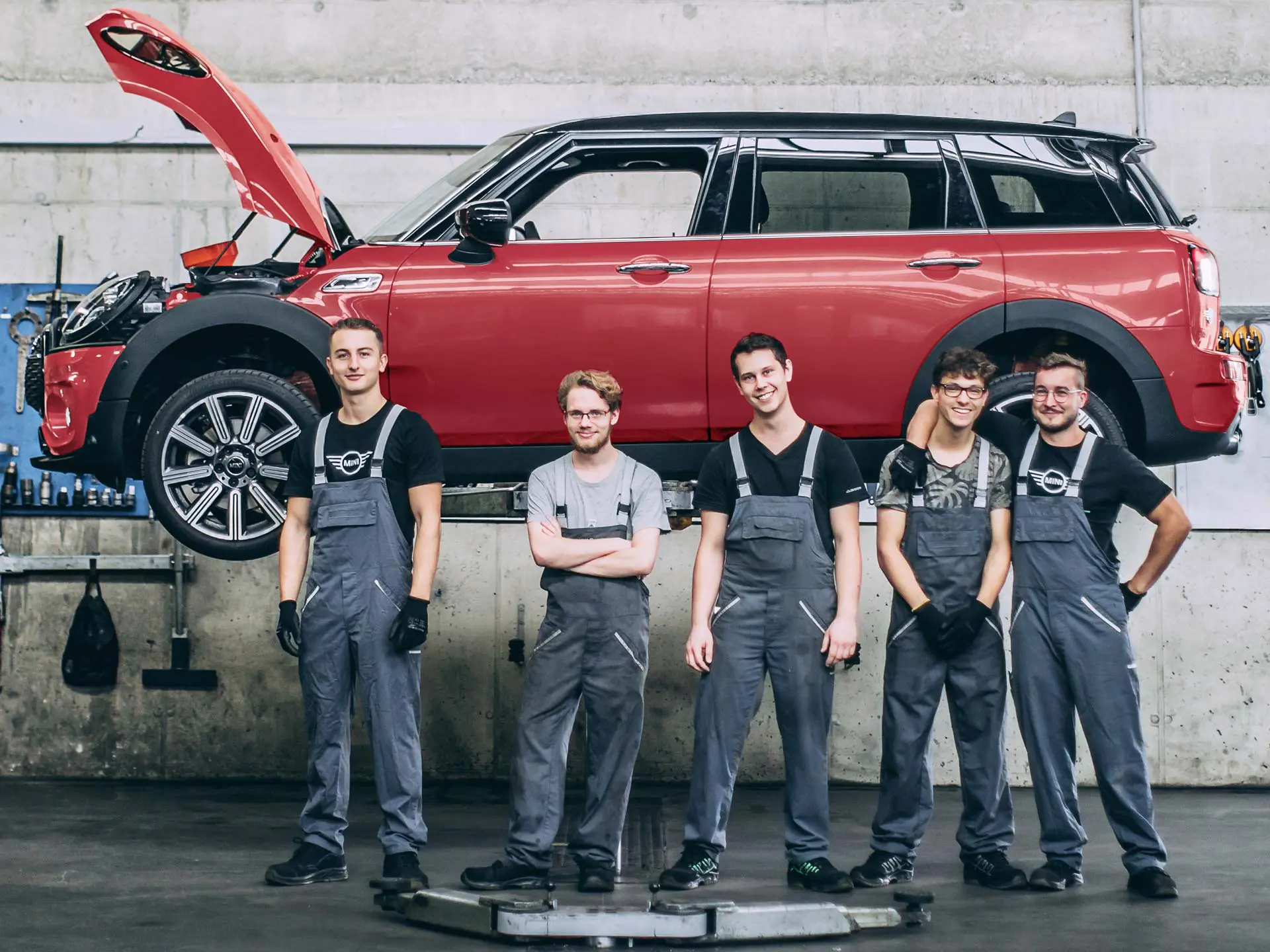 A MINI szerviz munkatársai egy emelőn lévő MINI Countryman előtt.