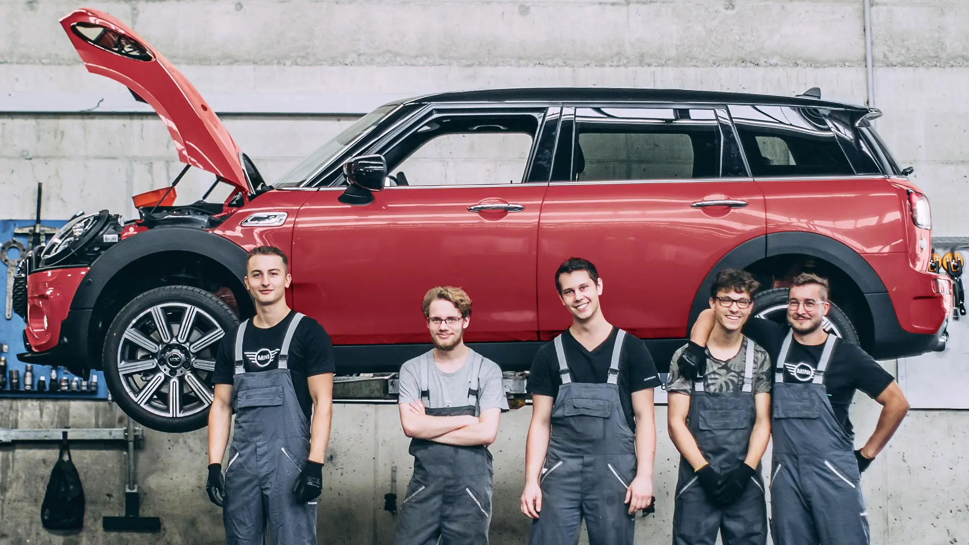 A MINI szerviz munkatársai egy emelőn lévő MINI Countryman előtt.
